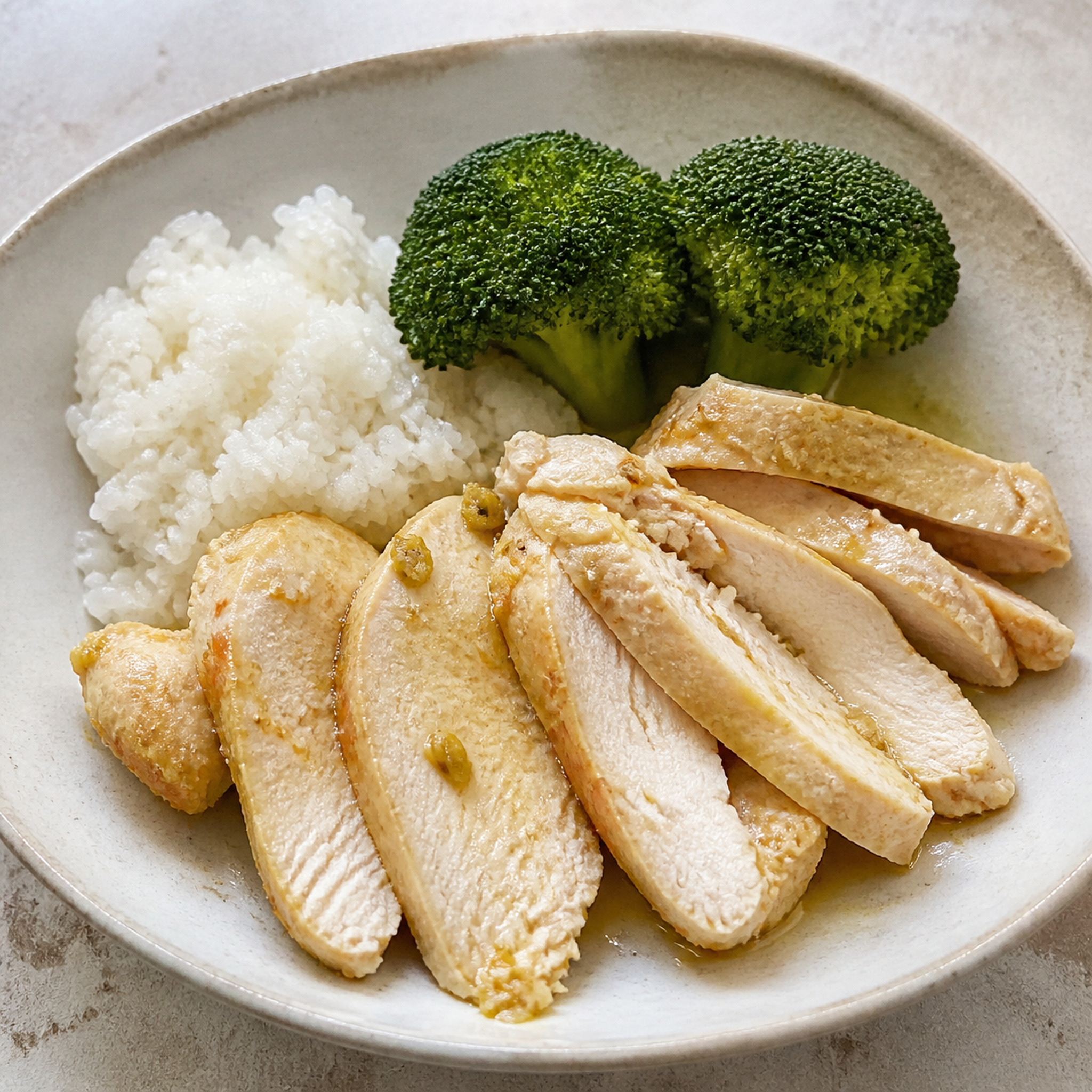 Thin slices of lemongrass baked chicken with rice and broccoli